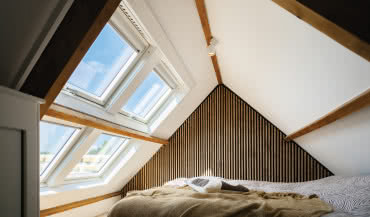 Słoneczna sypialnia na poddaszu z oknami dachowymi FAKRO