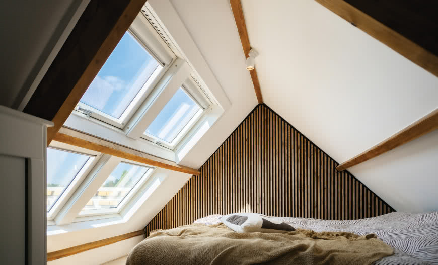 Słoneczna sypialnia na poddaszu z oknami dachowymi FAKRO