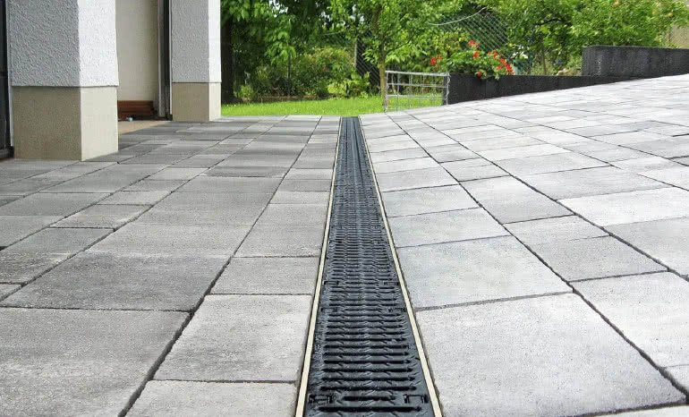 Systemy odprowadzania wody wokół domu – jak wybrać korytka ściekowe i odwodnienia liniowe?