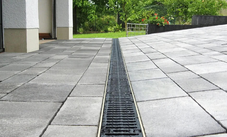 Systemy odprowadzania wody wokół domu – jak wybrać korytka ściekowe i odwodnienia liniowe?