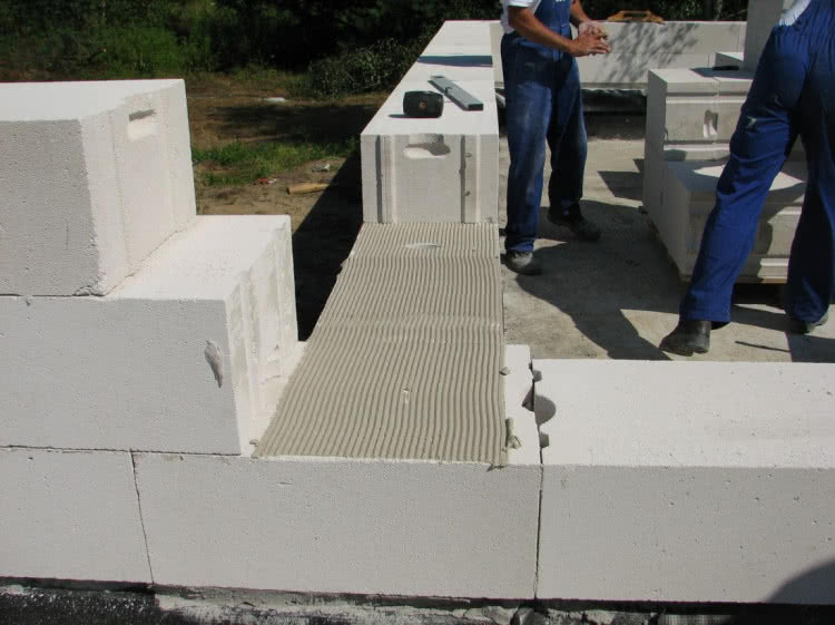 Nakładanie zaprawy na bloczki z betonu komórkowego