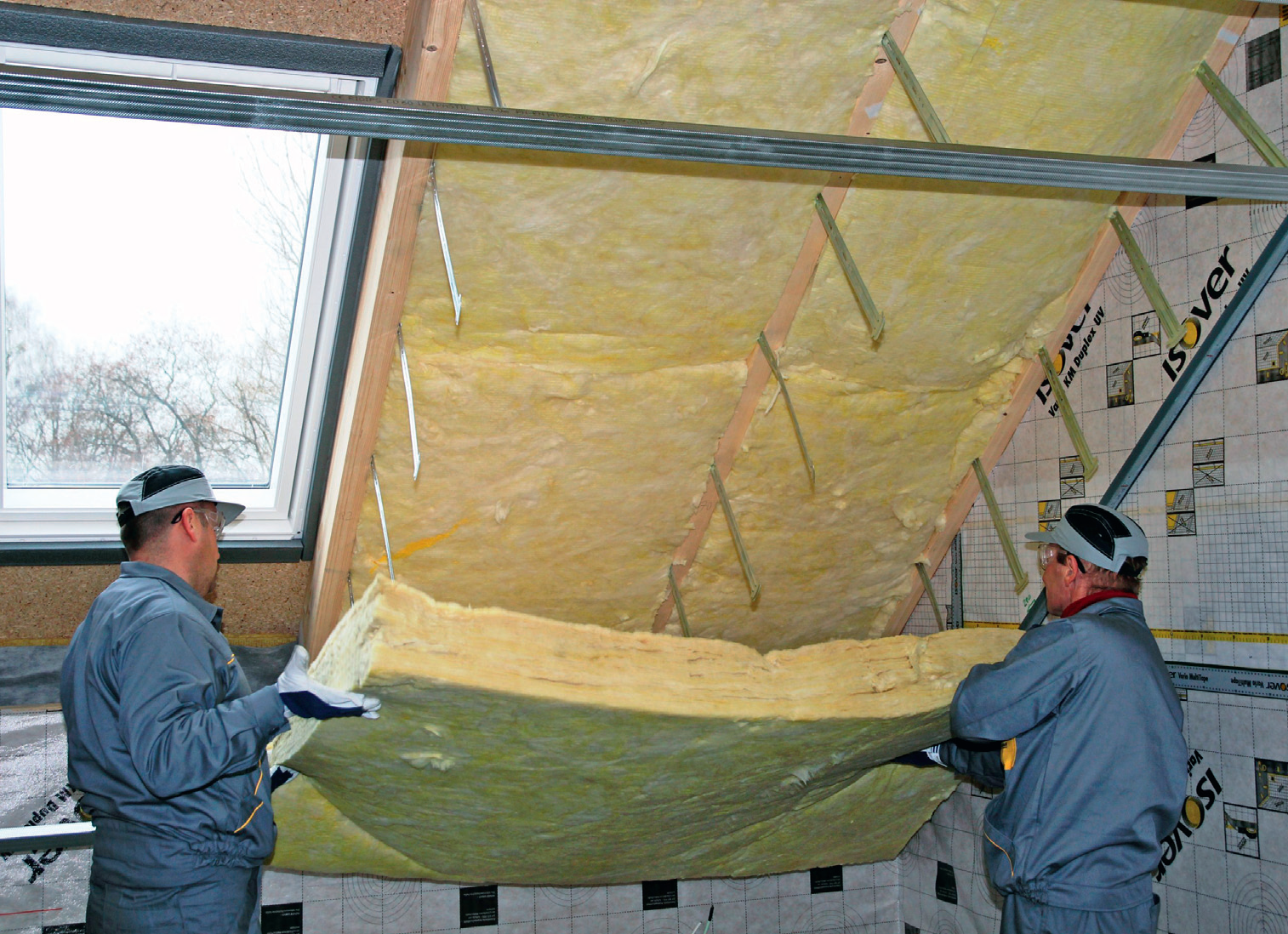 Układana w dwóch warstwach wełna mineralna osłania drewnianą konstrukcję dachu