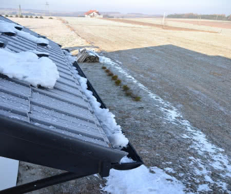 Zalegający śnieg na dachu jest przyczyną jego uszkodzeń.