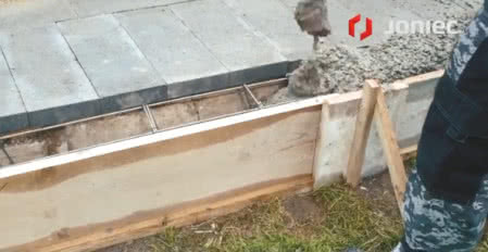 Zalewanie fundamentu ogrodzenia gotową mieszanką betonową, fot. JONIEC®